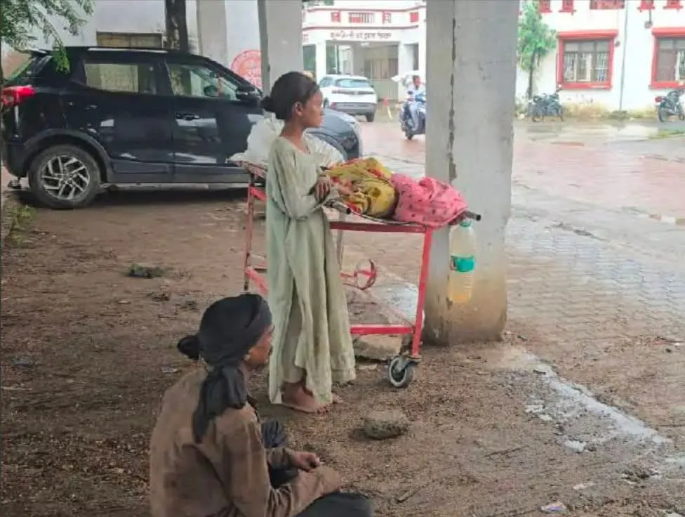 झांसी मेडिकल कॉलेज कैंपस में स्ट्रेचर पर रखा रहा पत्नी का शव, रोती रही बेटी, बेबस पति के पास एंबुलेंस के नहीं थे पैसे।